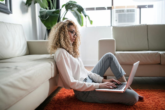 woman working on her laptop sitting on the floor